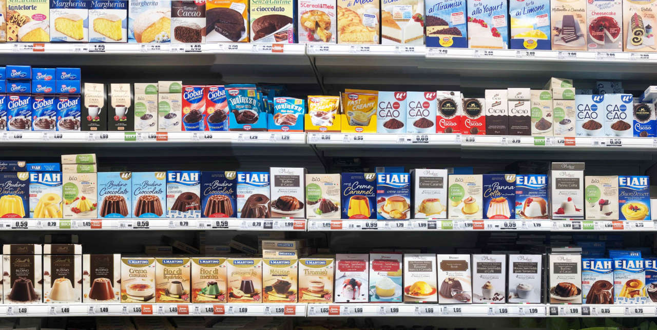 scaffale del supermercato con confezioni di creme e budini